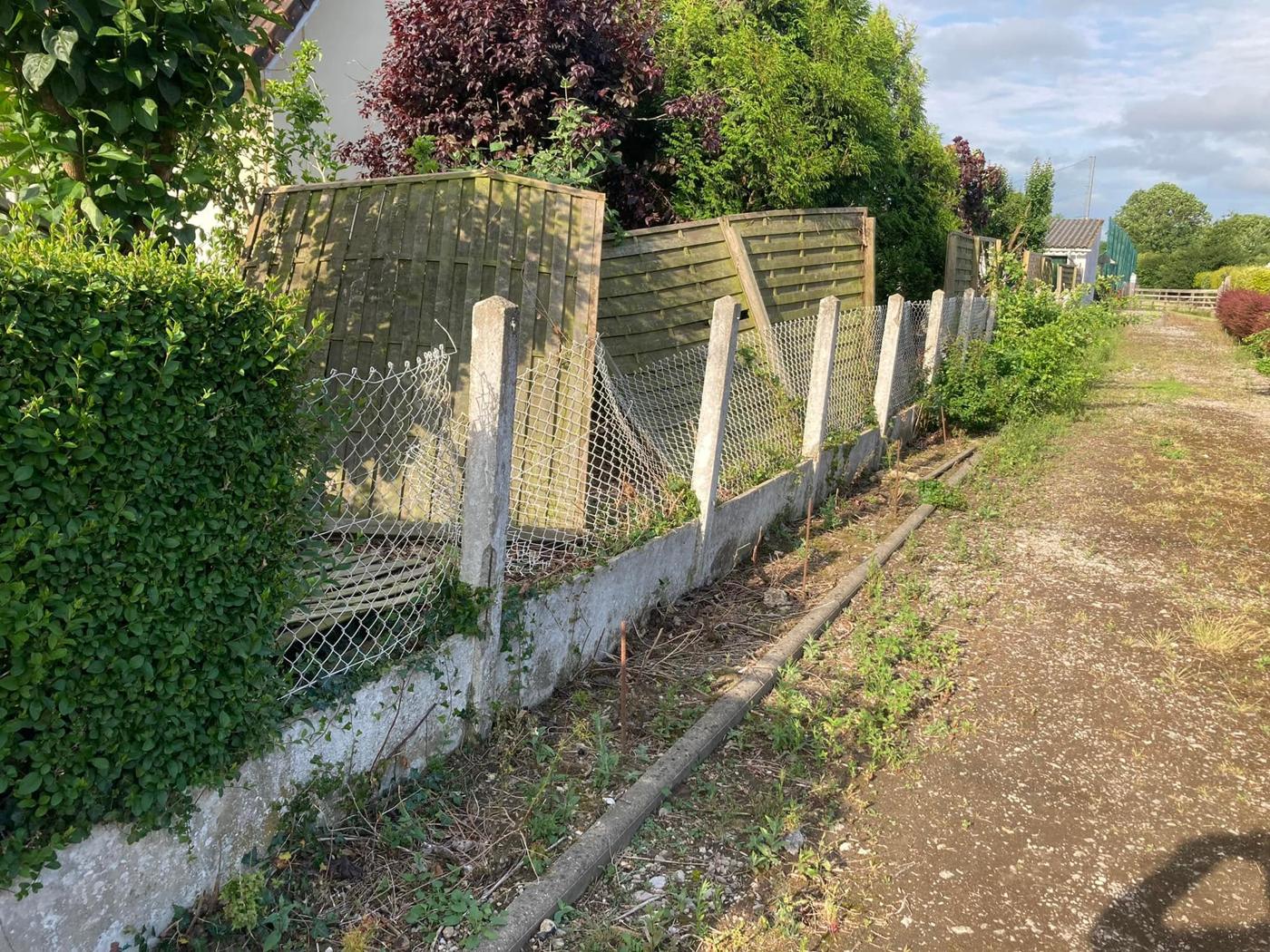 Ancienne clôture grillagée sur muret